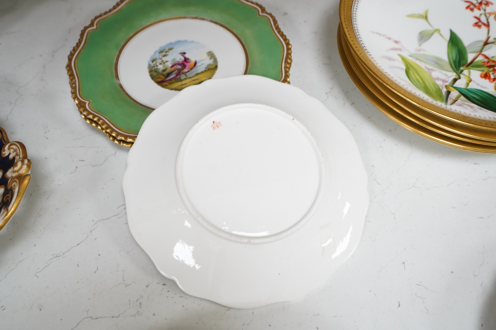 A collection of 19th century English dessert wares to include a pair of Flight, Barr and Barr ‘fantastic birds’ green ground dessert plates, various Ridgway dessert plates, five Minton botanical plates with tooled gilt b